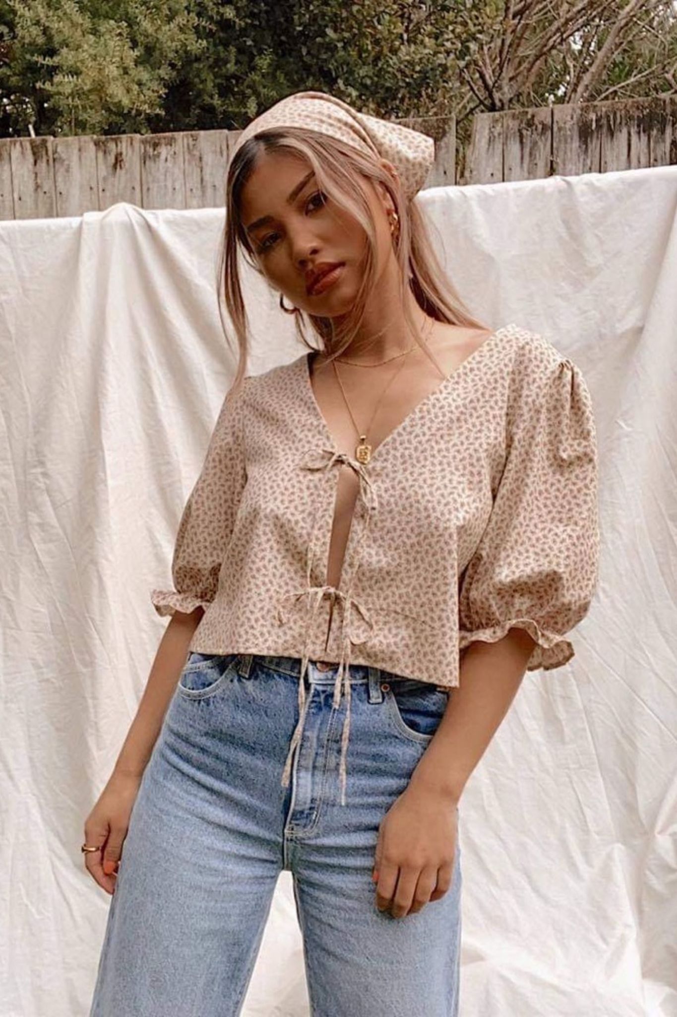 Woman wearing the Camille Top sewing pattern by Makyla Creates. A top pattern made in light to medium weight fabrics such as linens, cottons, silk, tencel or rayon fabrics, featuring a cropped length, loose fit, deep V-neck and two functional ties at the
