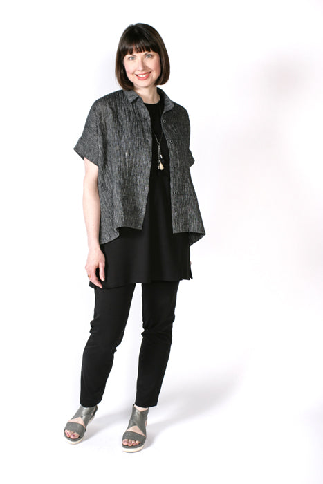 Woman wearing the Cottage Shirt sewing pattern from The Sewing Workshop on The Fold Line. A shirt pattern made in cotton, silk or linen fabrics, featuring a loose-fit, tailored collar with stand, back yoke, armhole bands, exaggerated hems with side vents