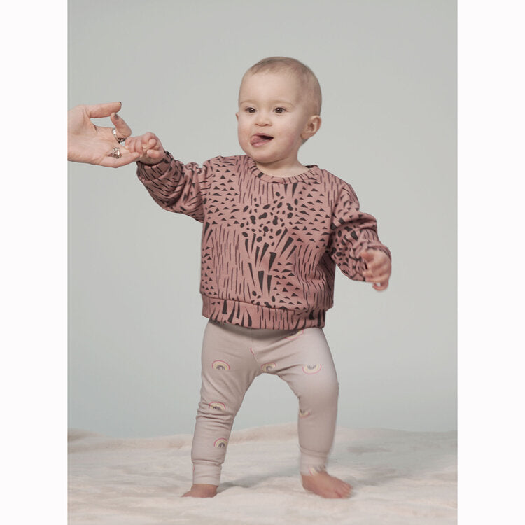 Toddler wearing the Scout Legging sewing pattern from Pattern Paper Scissors on The Fold Line. A leggings pattern made in jersey, knit, or cotton elastane fabrics, featuring an elasticated waistband, full length leg with cuffed hem.