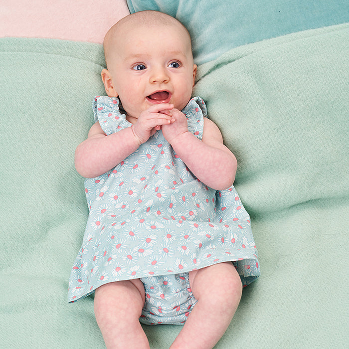 Babies wearing the Babies' Daffodil Dress and Pants sewing pattern from Poppy & Jazz on The Fold Line. A dress and pants pattern made in cotton lawn, cotton poplin, linen or broderie anglaise fabrics, featuring a dress with elasticated armholes and neckli