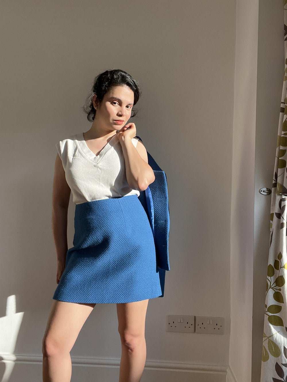 Woman wearing the Dulce Skirt sewing pattern from Bella Loves Patterns on The Fold Line. A skirt pattern made in tweeds/bouclé, suitings, denim, crepe, linen and cotton fabrics, featuring a high-waist, mini length, slight A-line shape, two front and back