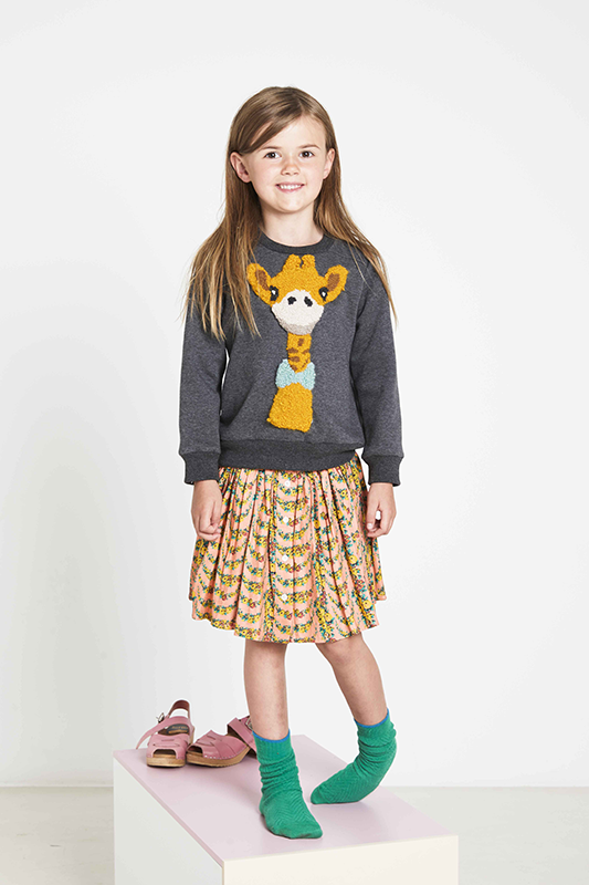 Child wearing the Child/Teen Phoenix Sweater sewing pattern from Fibre Mood on The Fold Line. A sweater pattern made in sweater fabrics, featuring a relaxed fit, ribbed cuffs, neck and hem band.