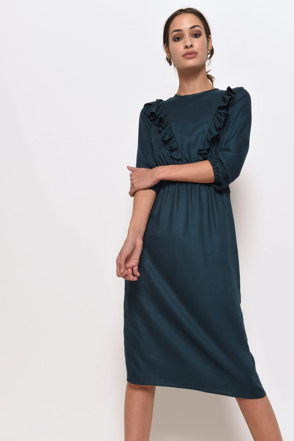 Woman wearing the Rosie Dress sewing pattern from Fibre Mood on The Fold Line. A dress pattern made in viscose, crepe or chiffon fabrics, featuring a round neckline, front bodice ruffles, elasticated waist, bracelet sleeves with elasticised hems and knee