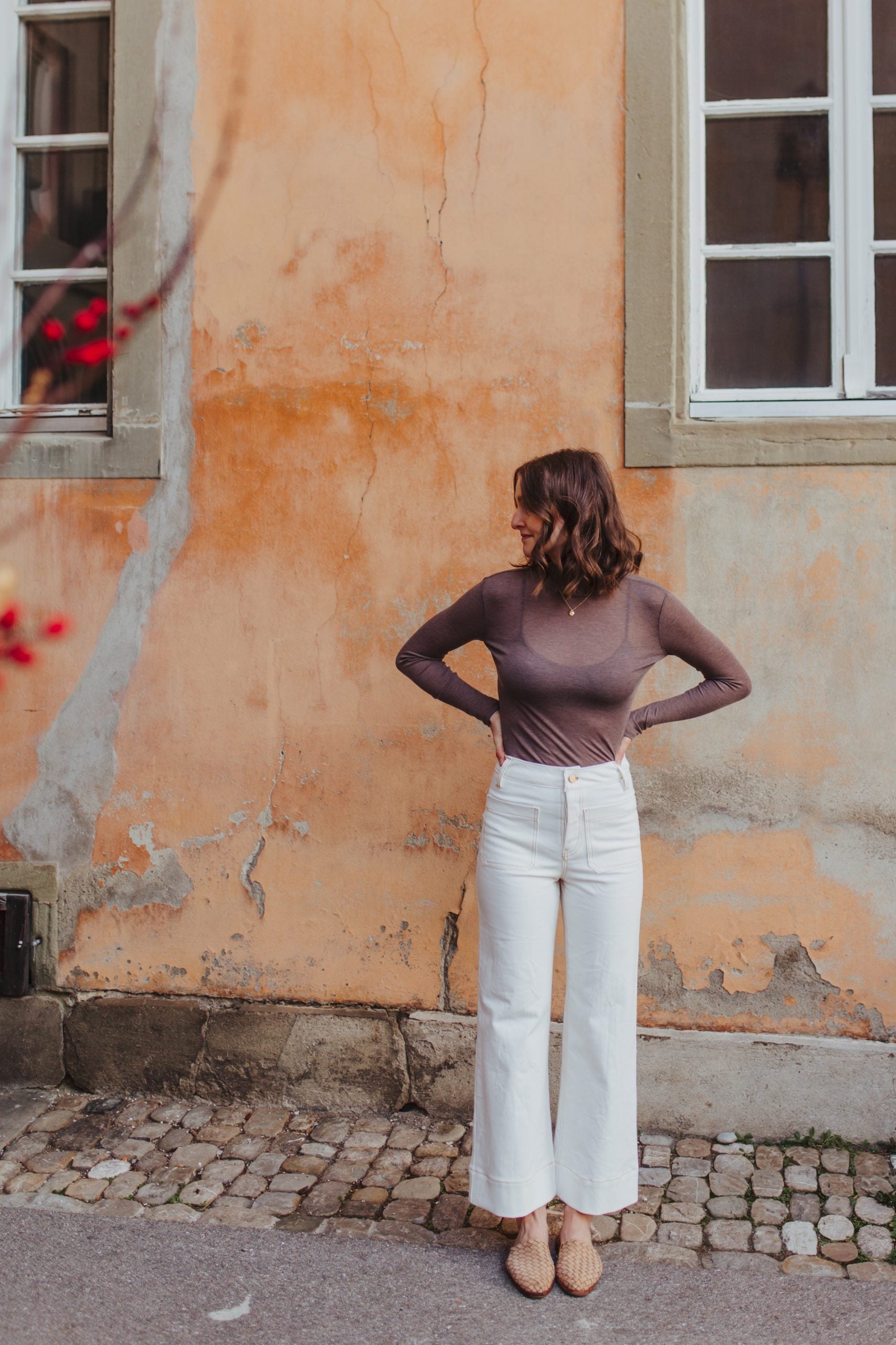 Woman wearing the Heidi Pants sewing pattern from Sewing Patterns by Masin on The Fold Line. A pants pattern made in denim, canvas, corduroy, twill, linen, or jacquard fabric, featuring a super high waist, wide legs, ankle length, button fly, front patch