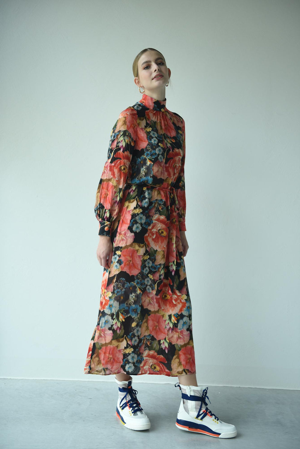 Woman wearing the Holly Dress sewing pattern from Fibre Mood on The Fold Line. A dress pattern made in fluid drape fabrics, featuring a stand collar, neckline gathers, invisible back zip, full length sleeves with gathers at the wrist, cuffs, relaxed fit,