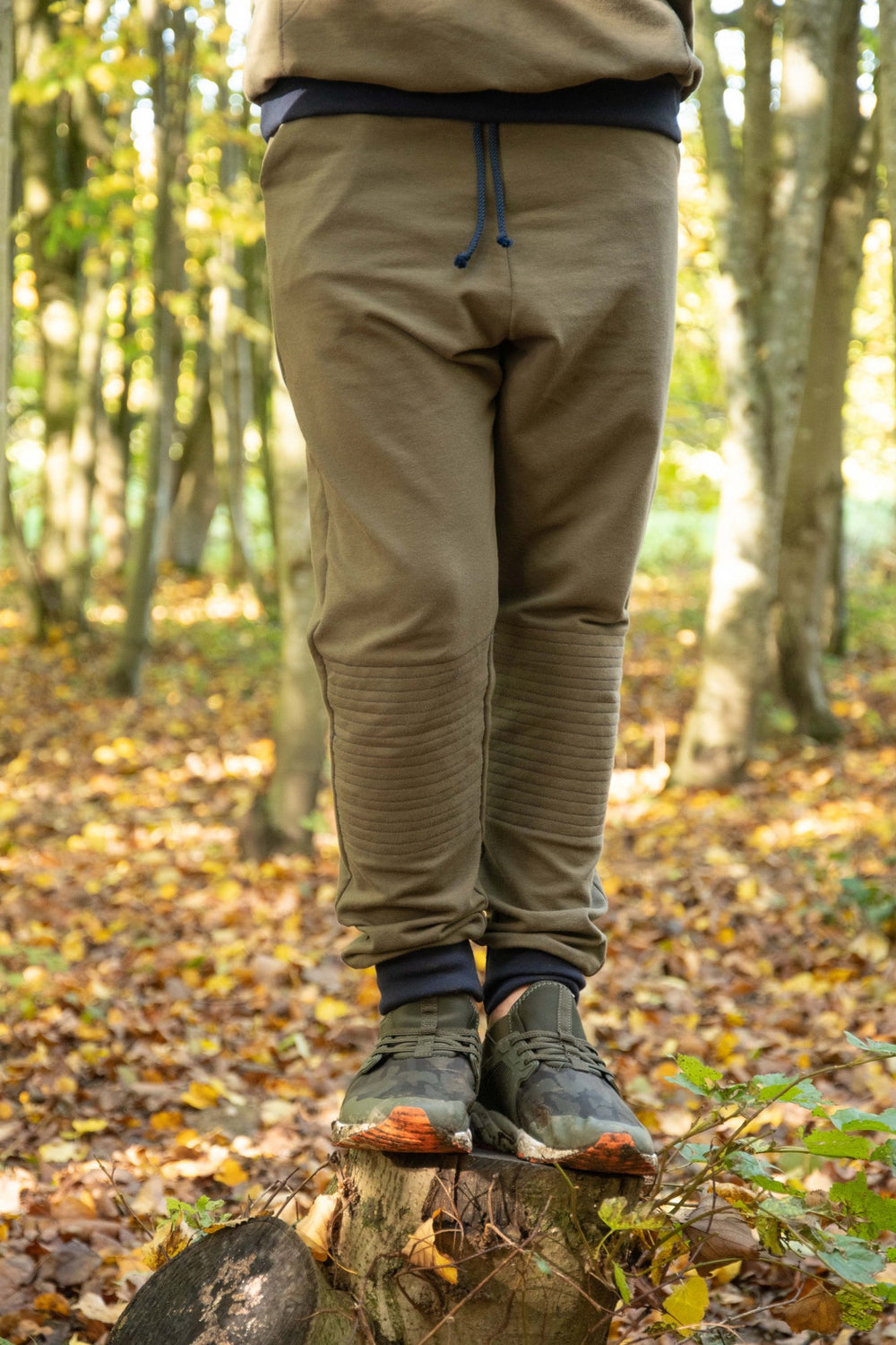 Child wearing the Baby/Child/Teen Joseph Joggers sewing pattern by Bobbins and Buttons. A joggers pattern made in sweatshirt fabrics, French terry or knitted fabric with at least a 30% stretch, featuring a slim fit, side pockets, knee patches and a waistb
