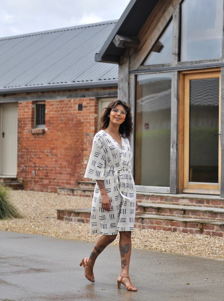 Woman wearing the Jumpset sewing pattern from The Avid Seamstress on The Fold Line. A dress pattern made in cotton, cotton lawn, poplin, corduroy, chambray, denim, linen, or tencel fabrics, featuring a wrap bodice, elasticated waist, V-neck, in-seam pocke