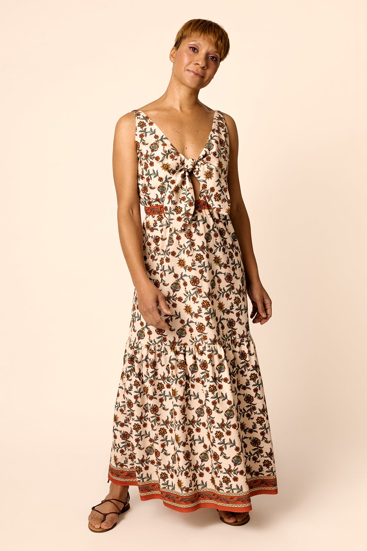 Woman wearing the Kerttu Knot Dress sewing pattern from Named on The Fold Line. A sleeveless sun dress pattern made in light cotton, linen or rayon challis fabrics, featuring a deep V-neck with tie and keyhole detail at the front, rounded back, spaghetti