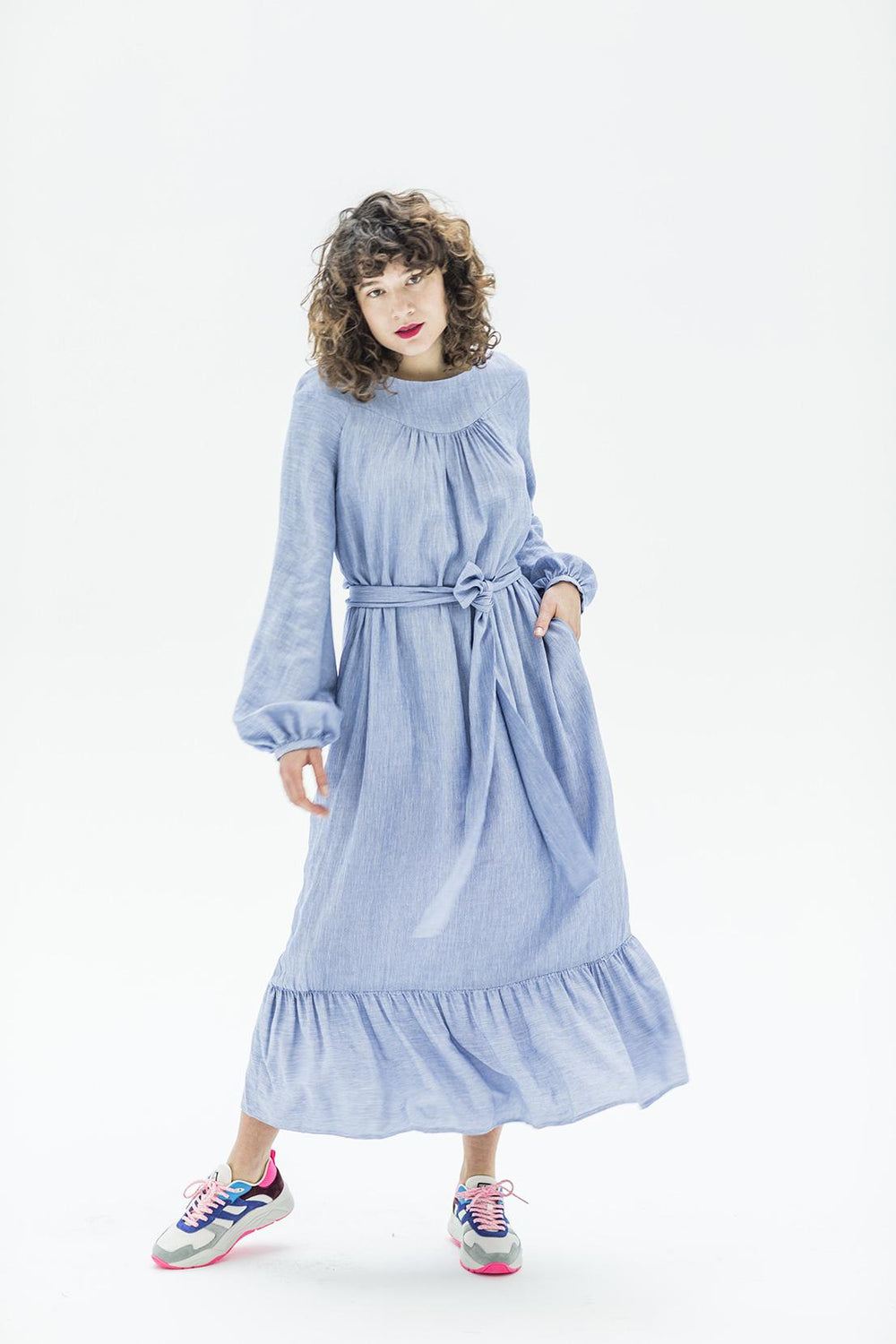 Woman wearing the Karlene Dress sewing pattern from Fibre Mood on The Fold Line. A dress pattern made in viscose (crepe), polyester (crepe), cotton or linen fabrics, featuring a round neckline, gathered front and back yoke, bishop sleeves, waist tie, side
