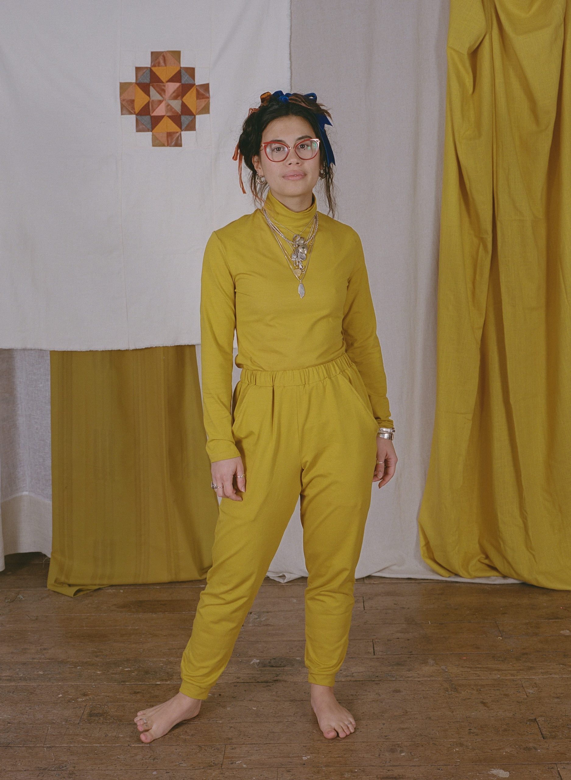 Woman wearing the Kezia Top sewing pattern from Made My Wardrobe on The Fold Line. A top pattern made in medium weight knit fabrics, featuring full length sleeves and turtleneck.