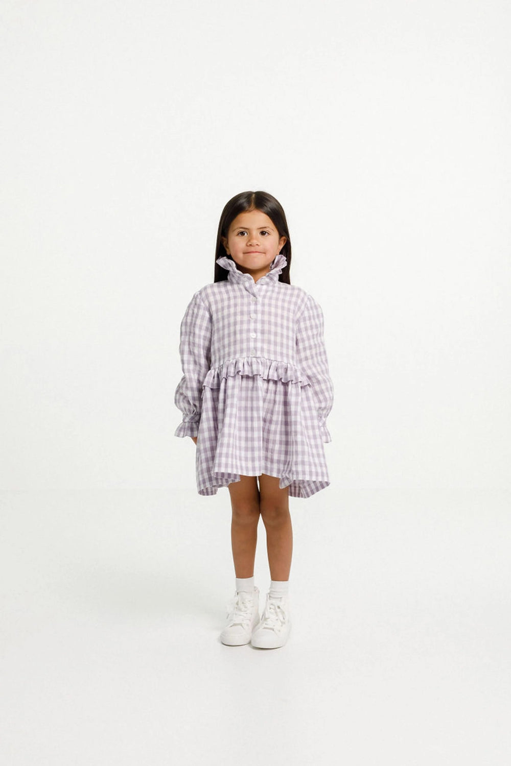 Child wearing the Ashling Dress sewing pattern from Papercut Patterns on The Fold Line. A dress pattern made in cotton, linen, silk, rayon or blends fabrics, featuring just above knee length, long sleeve with gathered cuffs, ruffle collar and waist, butto
