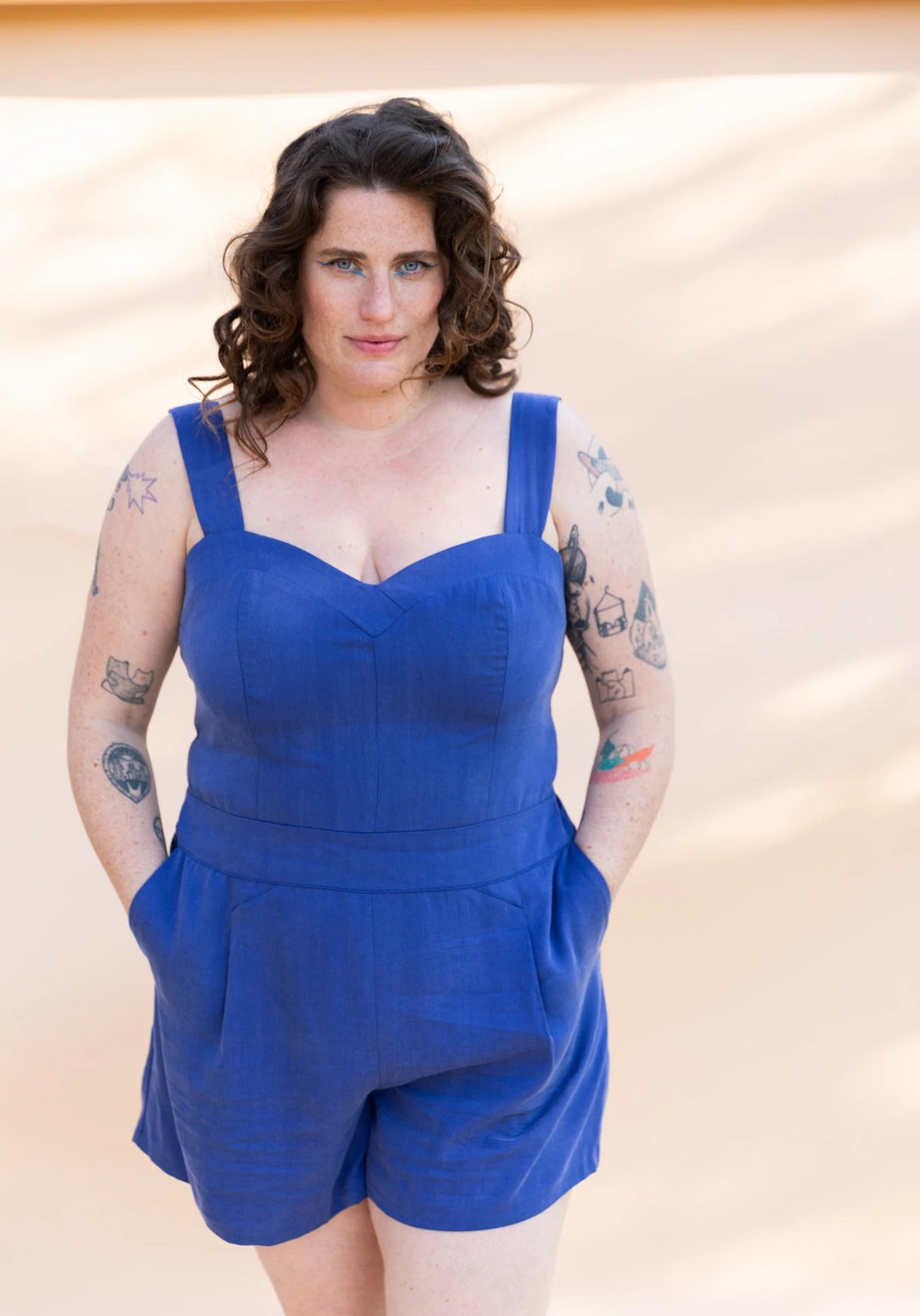 Woman wearing the Kika Jumpsuit sewing pattern from Maison Fauve on The Fold Line. A romper pattern made in twill, poplin, fine denim, tencel, viscose or cotton fabrics, featuring a bustier style top with elasticated back, shoulder straps, side invisible