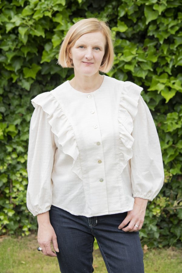 Woman wearing the Lewis Top sewing pattern from Bobbins and Buttons on The Fold Line. A semi fitted blouse pattern made in cotton poplin, broadcloth, chambray, medium weight linen, double gauze, cotton lawn, viscose or lyocell fabrics, featuring princess