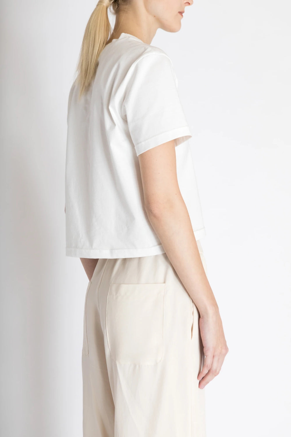 Woman wearing the Liv T-shirt sewing pattern from Bara Studio on The Fold Line. A T-shirt pattern made in jersey, interlock or fine knit fabrics, featuring a straight cut, slightly dropped shoulders and round neck.