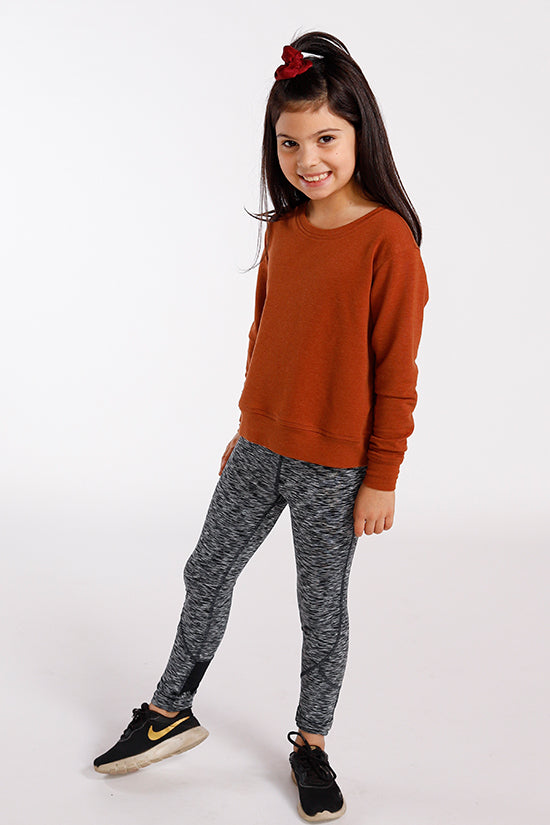 Child wearing the Baby/Child Mini Pixie Tee sewing pattern by Chalk and Notch. A tee pattern made in light to medium weight 75% – 100% stretch knit fabrics, featuring an oversized fit, dropped shoulders, long sleeves and round neck.