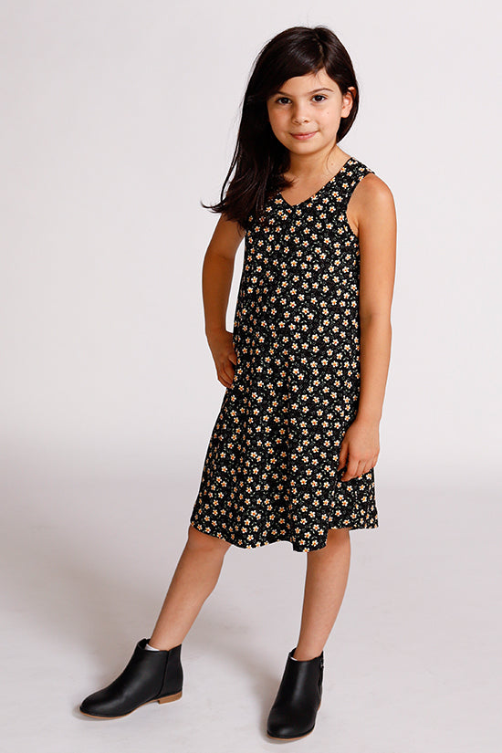 Child wearing the Baby/Child Mini Pony Dress sewing pattern by Chalk and Notch. A tank dress pattern made in light to medium weight 75% – 100% stretch knit fabrics, featuring an A-line silhouette, V-neckline and curved hem.