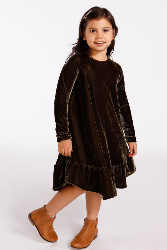 Child wearing the Baby/Child Mini Waterfall Raglan Dress sewing pattern by Chalk and Notch. A dress pattern made in light weight to medium weight 75% – 100% stretch knit fabrics, featuring a long slim fitting sleeve, hem ruffle and round neck.