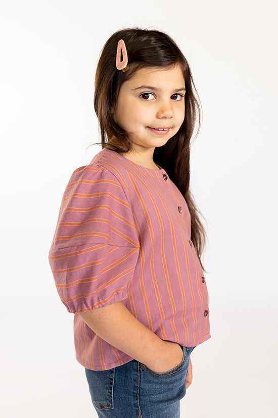 Child wearing the Baby/Child Mini Wren Blouse sewing pattern by Chalk and Notch. A blouse pattern made in rayon’s, cotton’s, linen or double gauze fabrics, featuring a button-front and short sleeves with an elastic cuff.