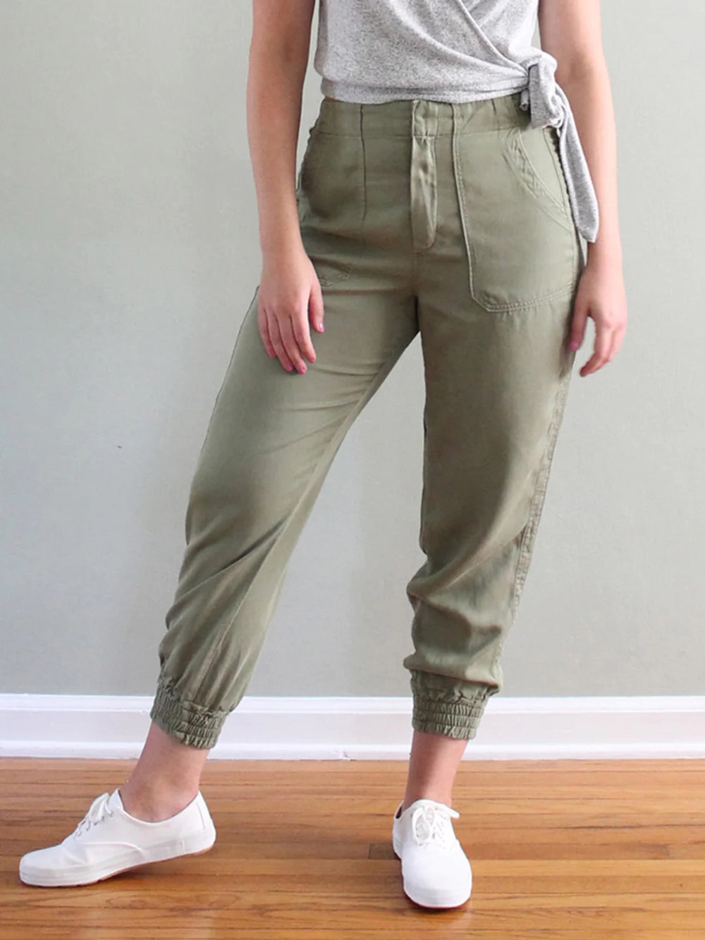 Woman wearing the Nellie Joggers and Shorts sewing pattern from Pattern Scout on The Fold Line. A jogger style trouser pattern made in medium weight woven fabrics, featuring a high rise waist, fly front closure, patch pockets, a ‘racing stripe’ along the