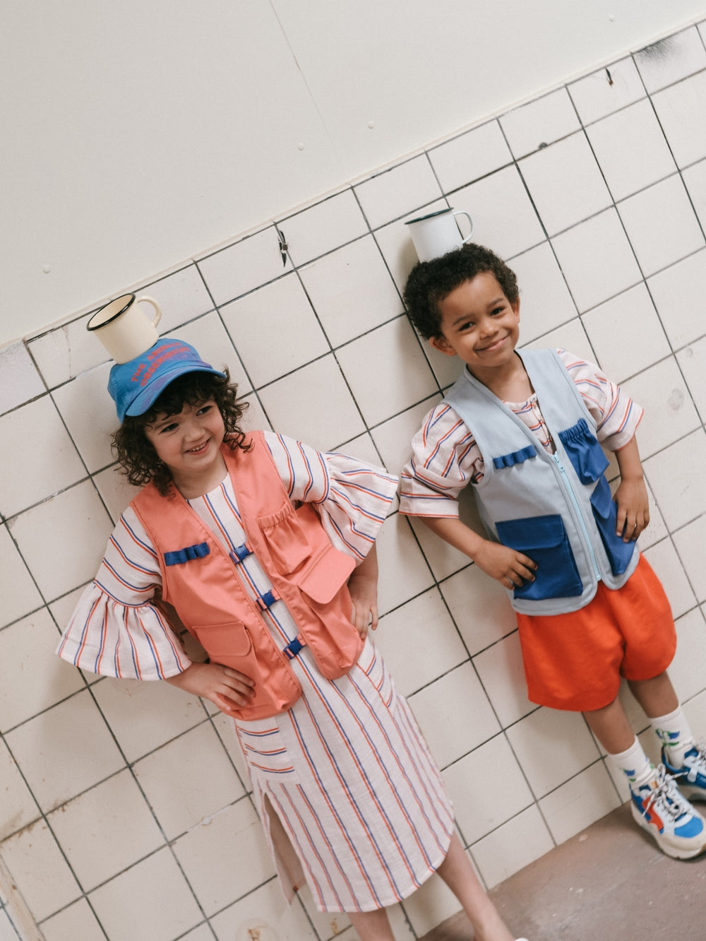 Children wearing the Child/Teen Benner Utility Vest sewing pattern from Notches on The Fold Line. A vest pattern made in canvas, twill, denim, corduroy, nylon, quilted, or teddy fabric, featuring lots of pockets, and no closures or a zip front.
