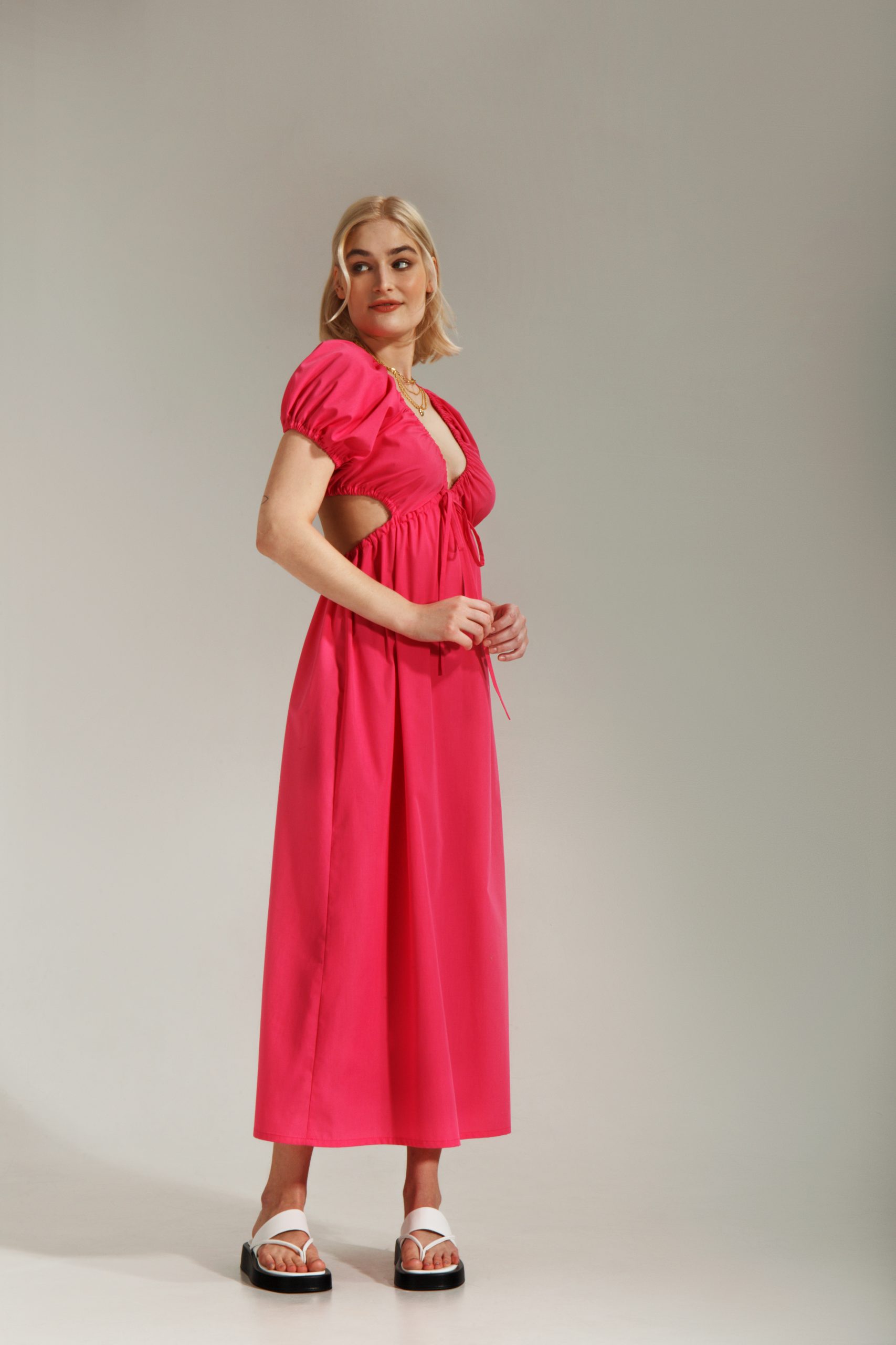 Woman wearing the Oona Dress sewing pattern from Vikisews on The Fold Line. A dress pattern made in sateen, poplin, linen, eyelet, opaque cotton shirting or viscose fabrics, featuring a semi-fit A-line silhouette, partially attached front bodice creating