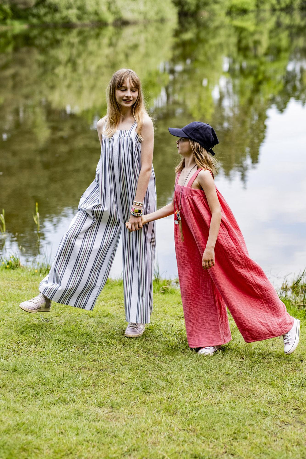 Children wearing the Children's Pearl Jumpsuit sewing pattern from Fibre Mood on The Fold Line. A jumpsuit pattern made in poplin, chambray, lyocell, double gauze, organza, seersucker or linen fabrics, featuring a relaxed fit, wide shoulder straps, side s