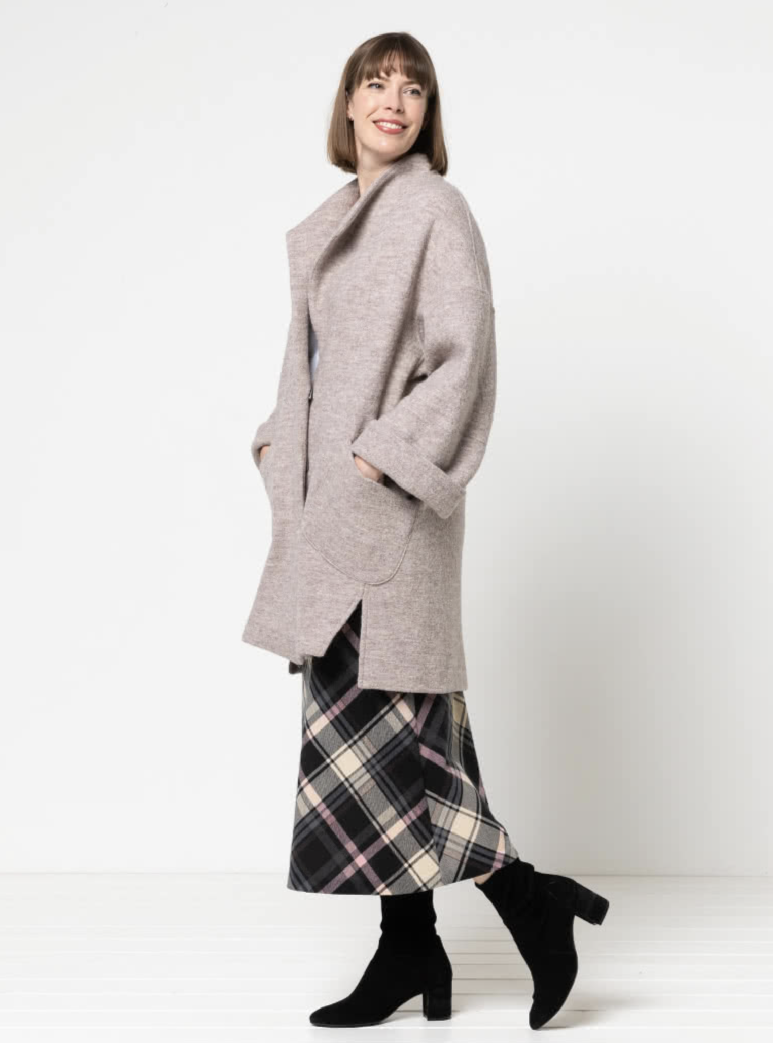 Woman wearing the Petra Coat sewing pattern from Style Arc on The Fold Line. A coat pattern made in boiled wool, wool, linen, or ponte fabrics, featuring a slightly oversized silhouette, knee length, dropped shoulders, wide sleeves, patch pockets, angled