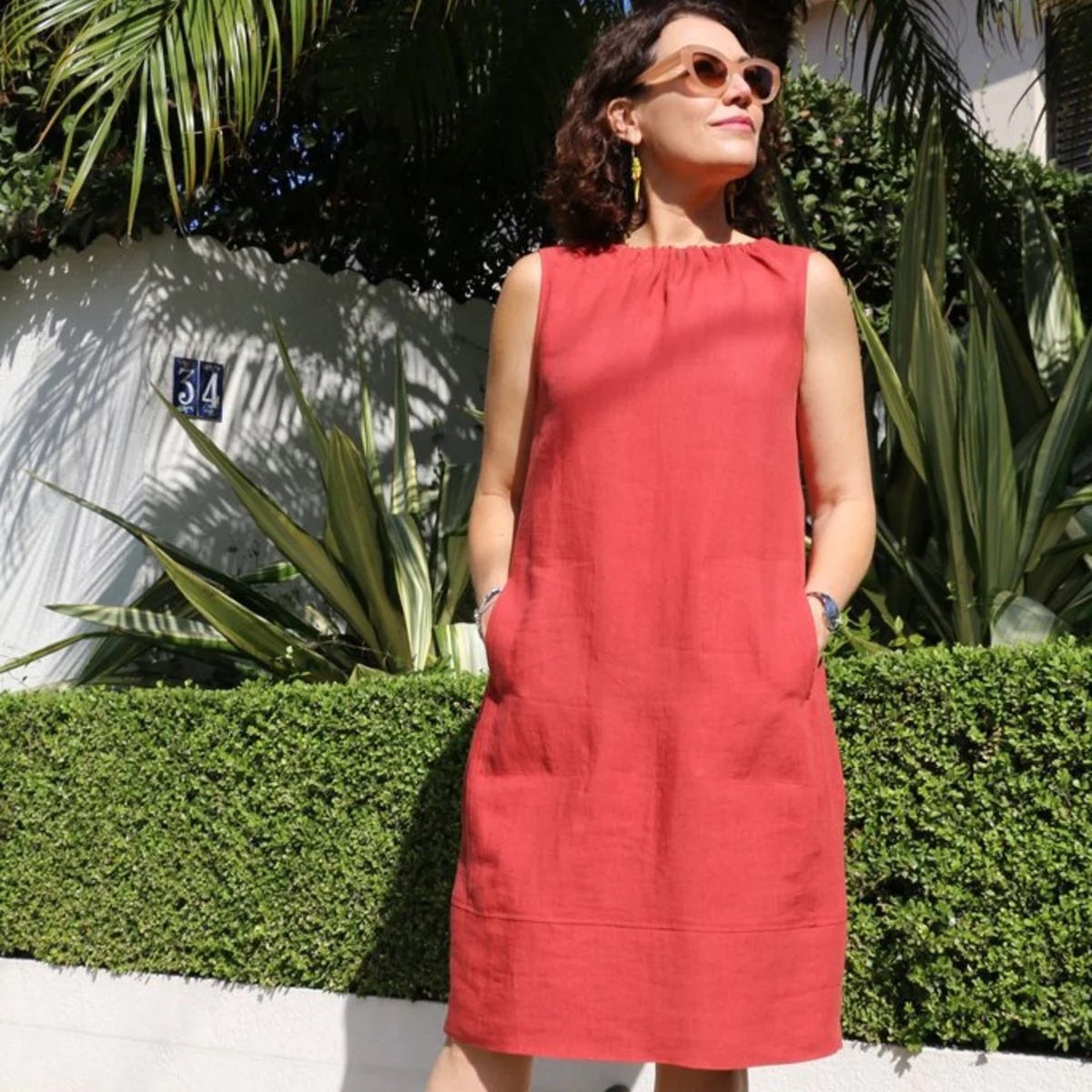 Woman wearing the Rae Dress sewing pattern from Tessuti Fabrics on The Fold Line. A dress pattern made in linen, cotton poplin, lightweight wool, and lightweight denim fabrics, featuring a deep lantern hem, knee length, pull-on shift style, wide gathered