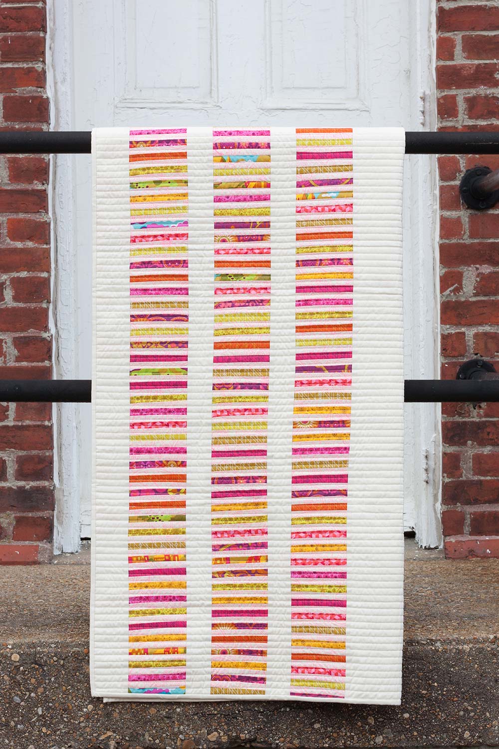 Photo showing the Read Between the Lines Quilt sewing pattern from Alison Glass on The Fold Line. A quilt pattern made in quilting cotton fabrics, featuring a simple line design.