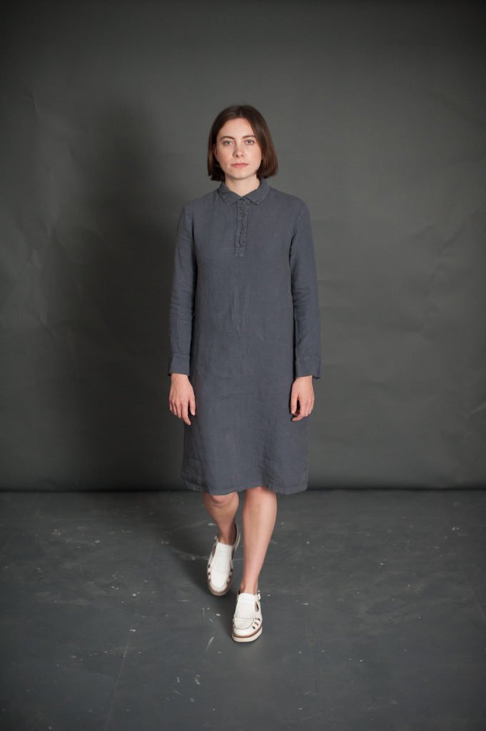 Woman wearing The Rugby Dress sewing pattern from Merchant & Mills on The Fold Line. A dress pattern made in light linens, fine wool, lightweight denim or silk fabrics featuring a semi-fit, rugby shirt style collar, cuffs and placket, full length sleeves