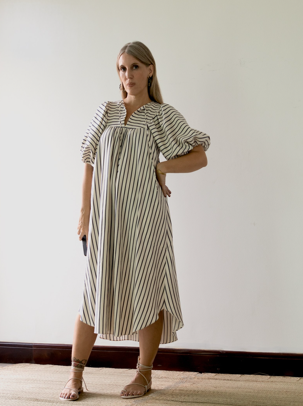 Woman wearing the Vali Dress sewing pattern from Pattern Fantastique on The Fold Line. A dress pattern made in viscose, silks, linen or cotton fabrics, featuring a high round neck with narrow V front opening with tie, sleeve and yoke gathers, topstitched