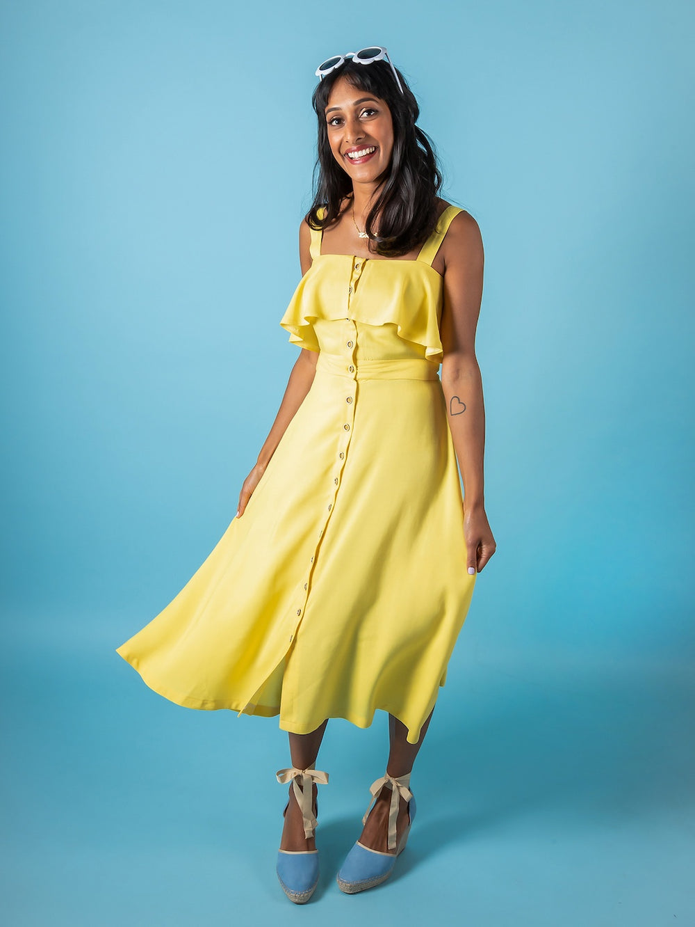 Woman wearing the Seren Dress sewing pattern from Tilly and the Buttons on The Fold Line. A dress pattern made in cotton lawn, chambray, shirting, seersucker, broderie anglaise, linen, viscose (rayon), or crêpe de chine fabric, featuring a button front, w