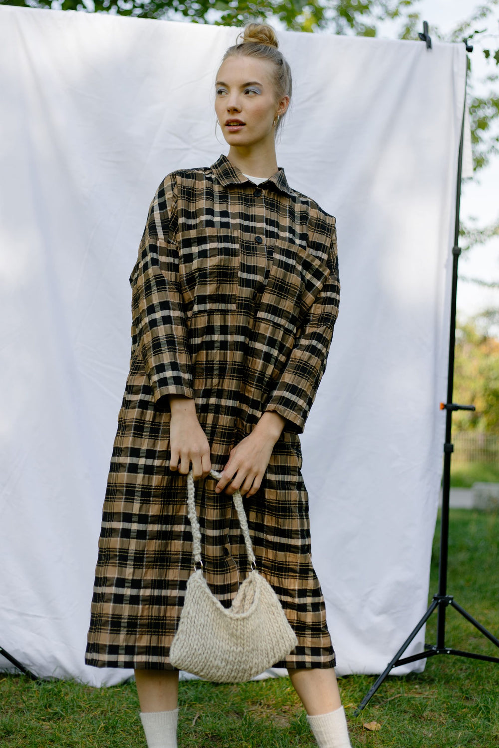 Woman wearing the Lola Blouse Dress sewing pattern from JULIANA MARTEJEVS on The Fold Line. A shirt dress pattern made in cotton poplin fabrics, featuring an oversized silhouette, midi length, long sleeves, single breast pocket, button front closure and s