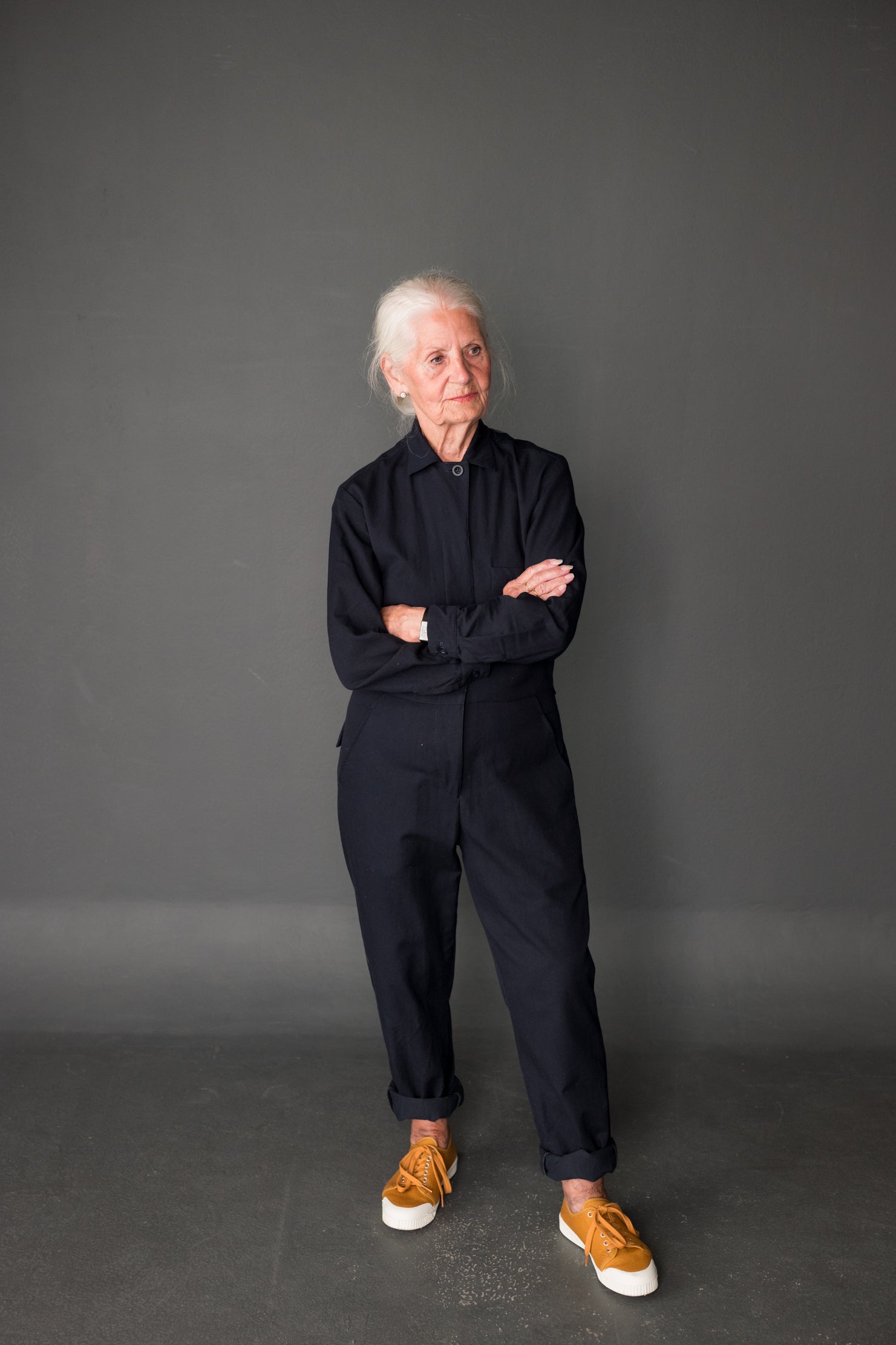 Woman wearing the Thelma Boilersuit sewing pattern from Merchant & Mills on The Fold Line. A boilersuit pattern made in sanded twill, denims, linens, and cotton poplin fabrics, featuring a relaxed fit, collar and stand, full length sleeve with button cuff