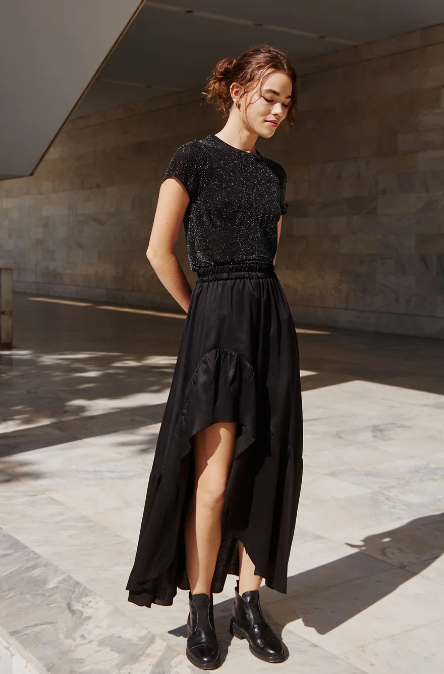 Woman wearing the Valeria Skirt sewing pattern from The Patterns Room on The Fold Line. A skirt pattern made in viscose, tencel, crepe or satin fabrics, featuring a high-low style, gathered asymmetric hem panel, relaxed fit, and elasticated waistband.
