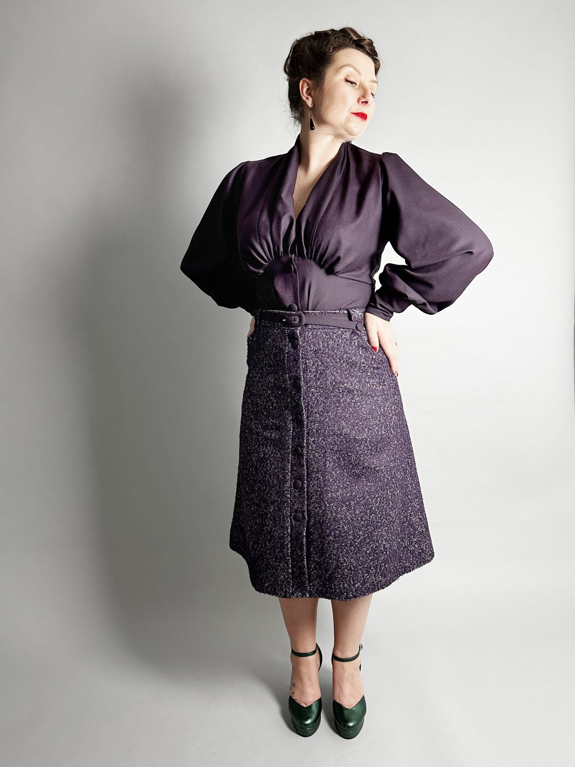 Woman wearing the No. 30 Verona Skirt sewing pattern from How to Do Fashion on The Fold Line. A skirt pattern made in cotton, silk, wool, viscose, cupro, linen, or polyester fabric, featuring a 1940s-inspired A-line silhouette, front button placket, belt