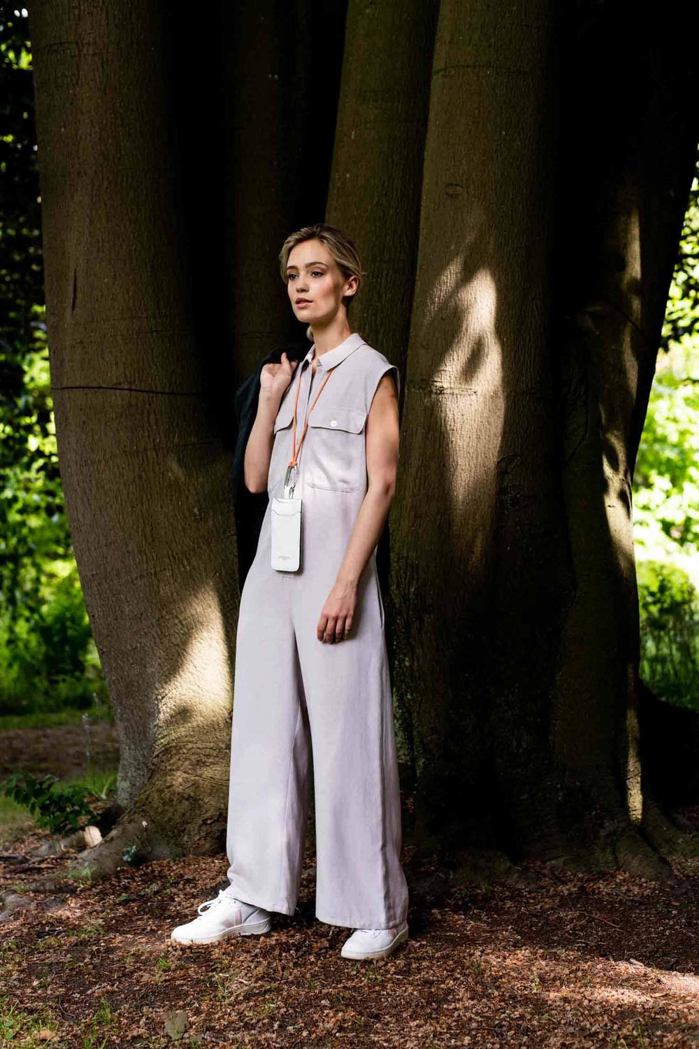 Woman wearing the Veronica Jumpsuit sewing pattern from Fibre Mood on The Fold Line. A jumpsuit pattern made in twill cotton, poplin, denim, fine rib velvet, or linen fabrics, featuring rounded chest pockets with a button flap, lapped seams have decorativ