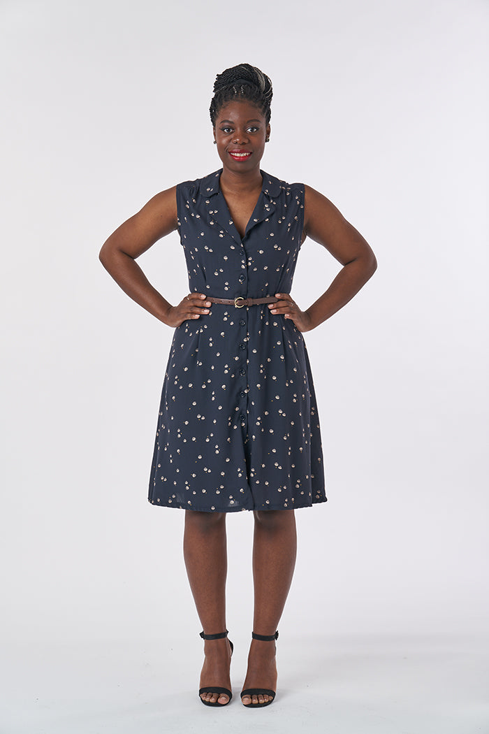 Woman wearing the Vintage Shirt Dress sewing pattern from Sew Over It on The Fold Line. A shirt dress pattern made in cotton, cotton lawn, seersucker, rayon and crepe fabrics, featuring no sleeves, above and below waist pleats, notched collar, knee length