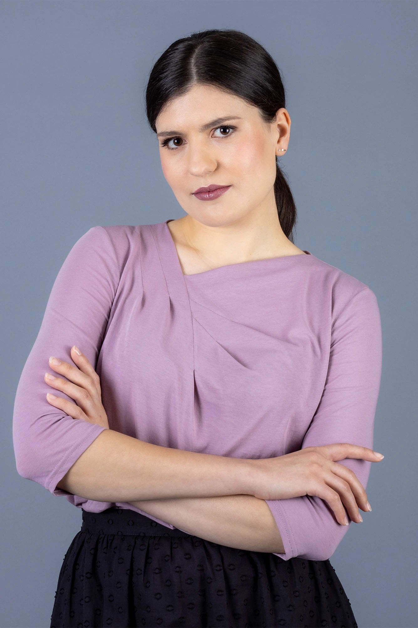 Woman wearing the Viola Top sewing pattern from Forget-Me-Not-Patterns on The Fold Line. A blouse pattern made in cotton jersey, viscose/rayon jersey, merino jersey, or silk jersey fabrics, featuring a collarless asymmetric neckline with draped folds, gen