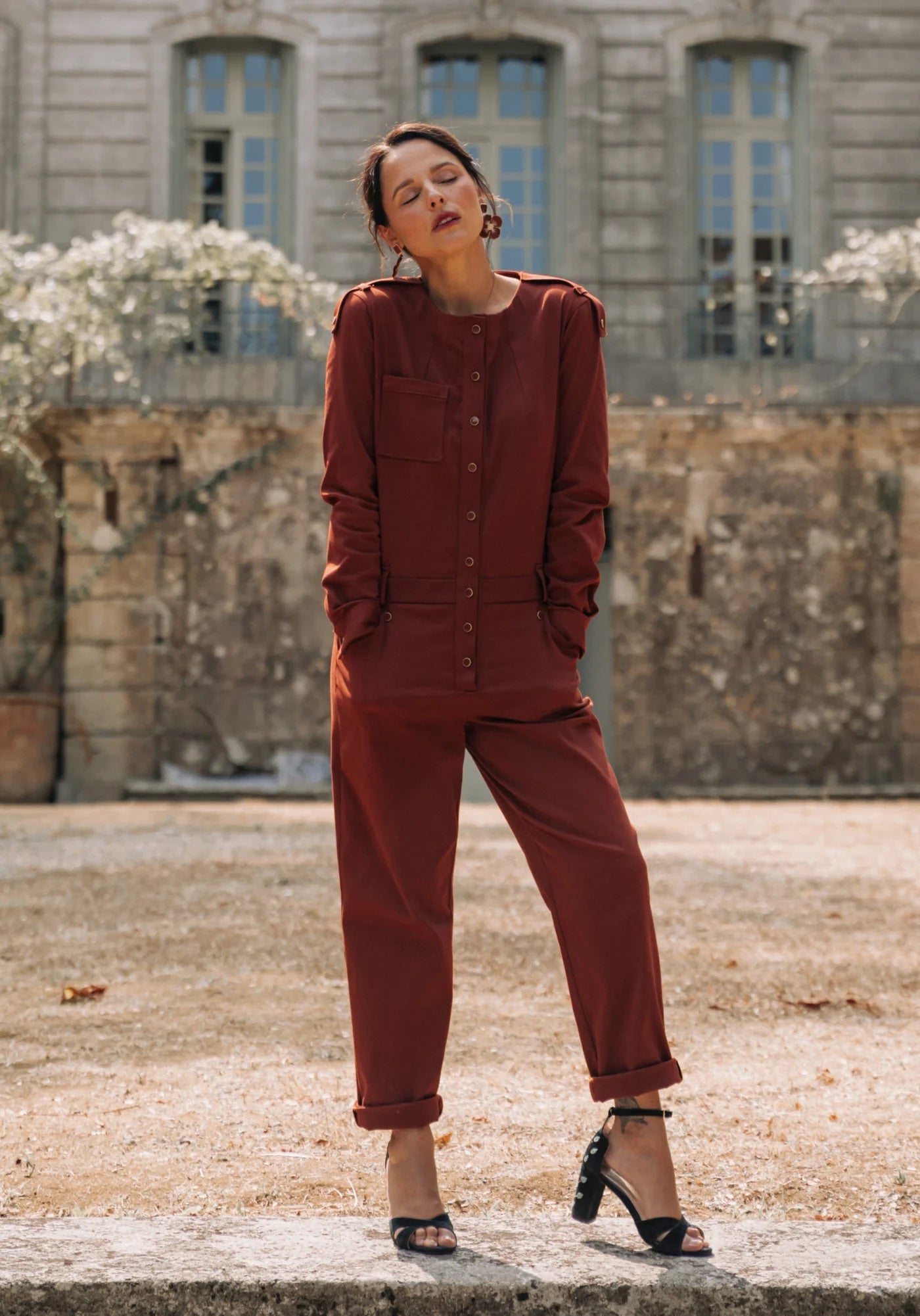 Woman wearing the Vipère Jumpsuit sewing pattern from Maison Fauve on The Fold Line. A jumpsuit pattern made in cotton sateen, velvet, jacquard, fine wool, or supple denim fabrics, featuring a round neckline, shoulder button tabs, neck darts, chest patch