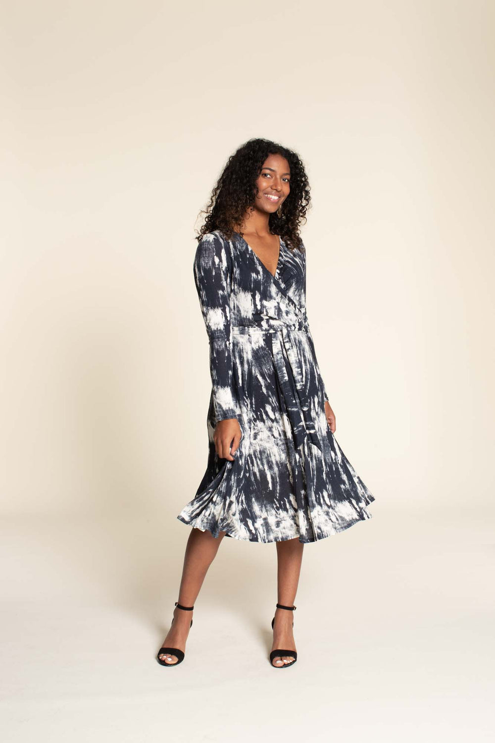 Woman wearing the Wanda Dress sewing pattern from Wardrobe by Me on The Fold Line. A wrap dress pattern made in light weight jersey fabrics, featuring a six-gore skirt, full length sleeves, V-neckline, and knee length hem.