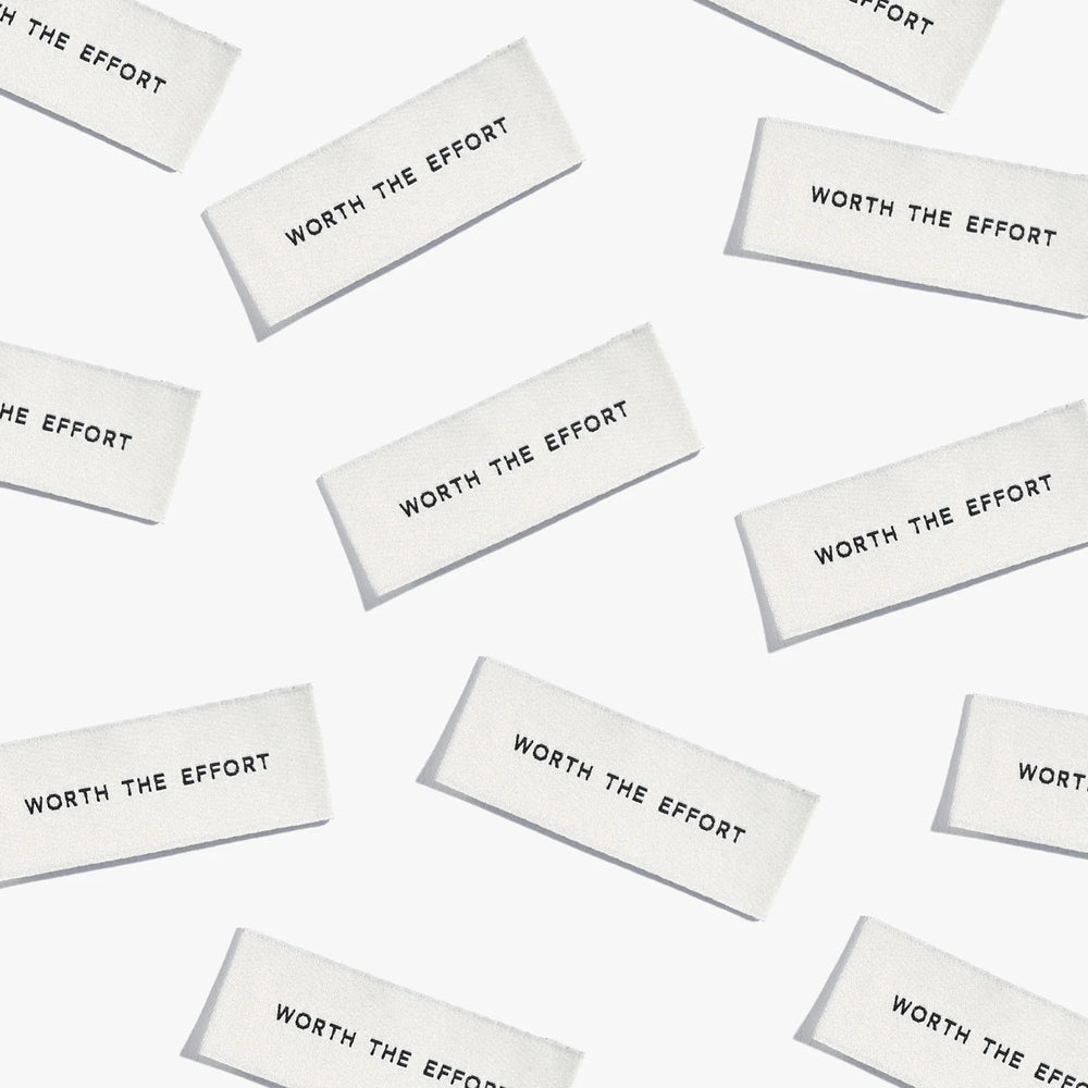 Photo showing 'Worth the Effort' Cotton Labels from Kylie & The Machine on The Fold Line. A washable, durable, and non-scratchy cotton label featuring white coloured backgrounds with black text, they are all ready to be sewn into your handmade clothes.