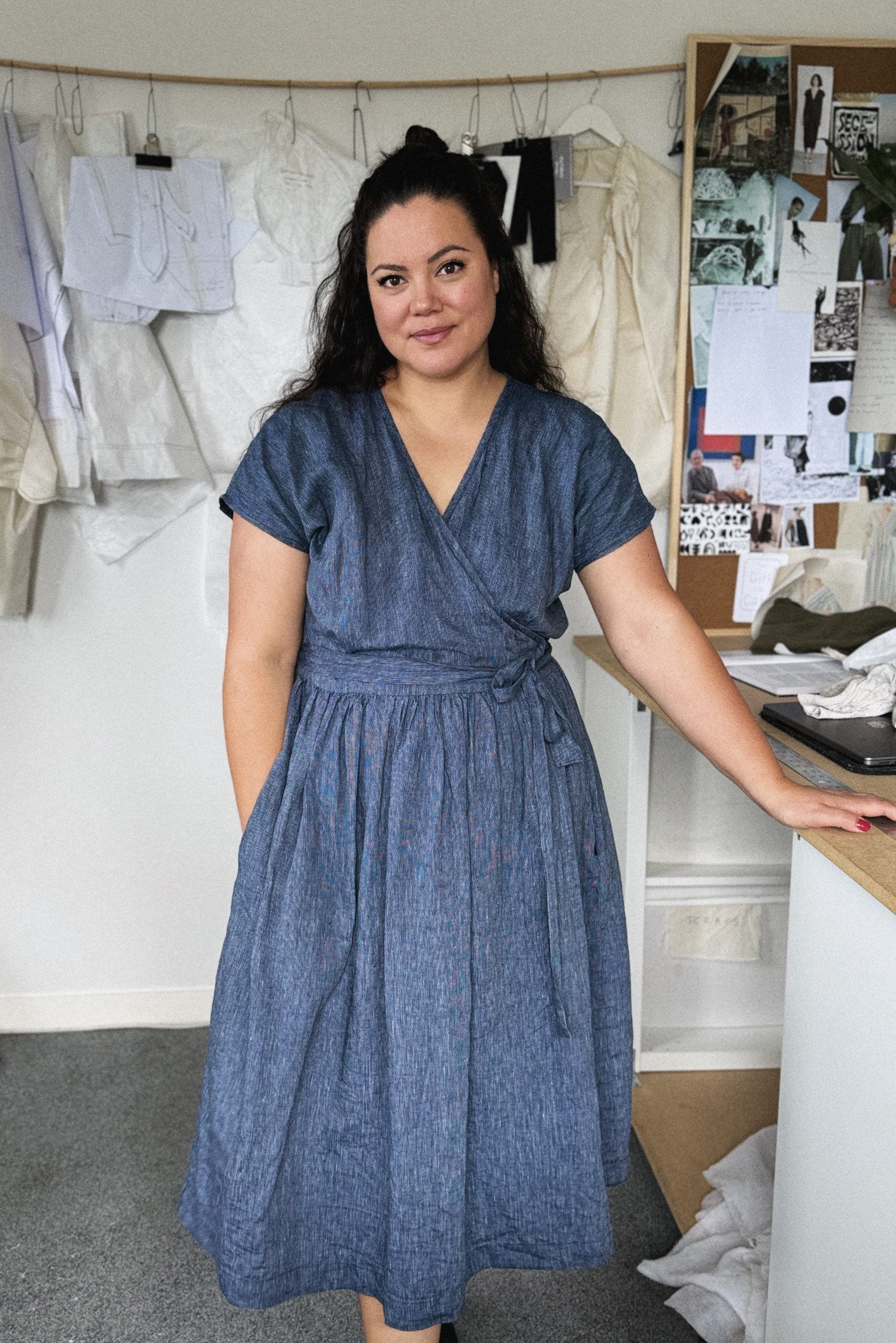 Woman wearing the Zadie Dress sewing pattern from Paper Theory Patterns on The Fold Line. A wrap dress pattern made in cotton, linen, crepe, viscose twill or satin fabrics, featuring a relaxed fit, tie belt, sleeveless with dropped shoulder, midi length,