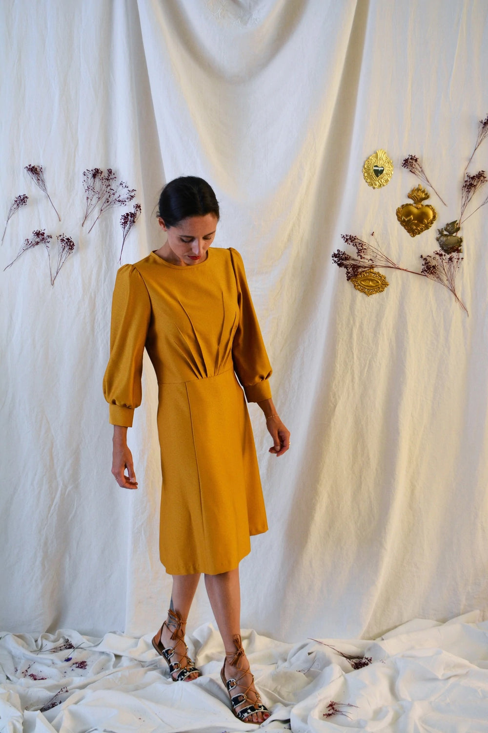 Woman wearing the Zenith Dress sewing pattern from Maison Fauve on The Fold Line. A dress pattern made in viscose, cotton, tencel, linen silk fabrics, featuring a round neckline, bracelet length voluminous sleeves with deep cuffs, darts radiating upwards