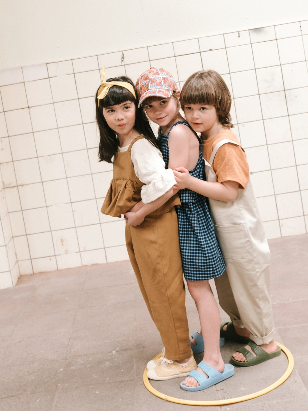 Children wearing the Child/Teen Kai Jumpsuit and Pinafore sewing pattern from Notches on The Fold Line. A jumpsuit and pinafore pattern made in linen, gabardine, cotton twill, poplin, thin velvet, double gauze, french terry, or denim-like fabric, featurin