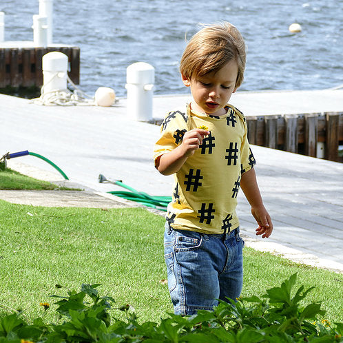 Child wearing the Child/Baby Fitted Tee sewing pattern from Elemeno Patterns on The Fold Line. A T-shirt pattern made in cotton knit fabrics, featuring a lap neck and elbow length sleeves.