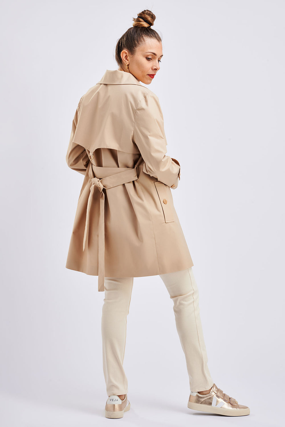 Woman wearing the Bob Trench Coat sewing pattern from I AM Patterns on The Fold Line. A coat pattern made in gabardine, twill, waxed canvas, denim, or lightweight quilted fabrics, featuring a straight cut, mid-thigh length, back storm flap with metal D-ri