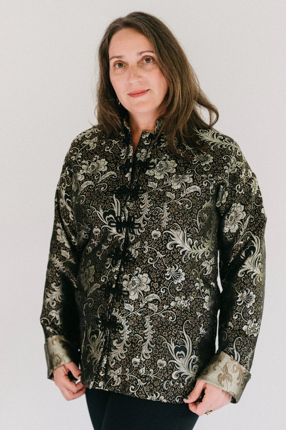 Woman wearing the 145 Unisex Chinese Pajamas sewing pattern from Folkwear on The Fold Line. A Unisex Pyjama pattern made in silks, cottons, lightweight denim, corduroy, or lightweight wool fabrics, featuring a fully lined mid-thigh jacket, stand-up collar