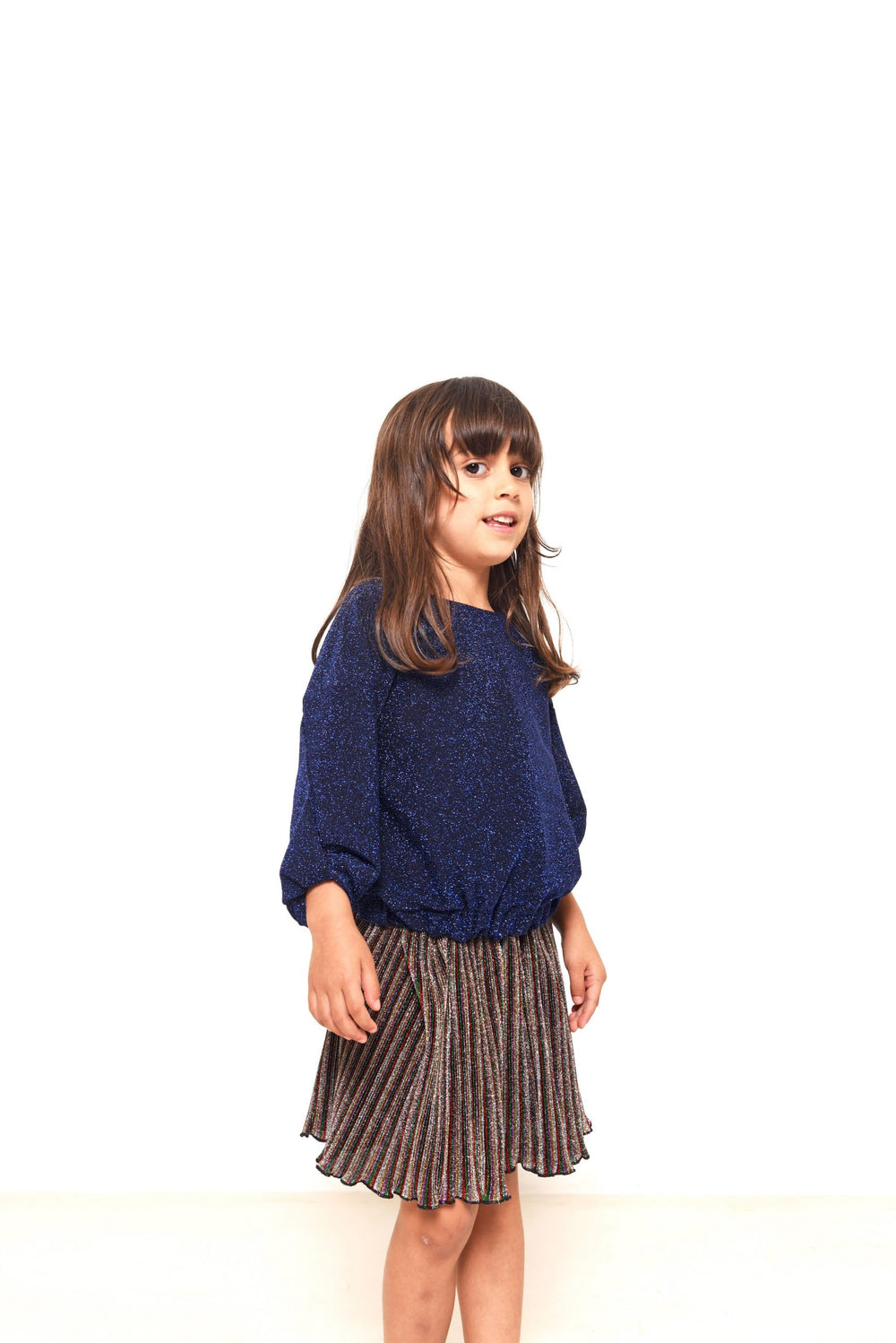 Child wearing the Child/Teen Goldie Top sewing pattern from Fibre Mood on The Fold Line. A jumper/knit top pattern made in French terry, sweater knits or ponte roma fabrics, featuring a loose-fit, round neck, snap closure on one shoulder, dropped shoulder