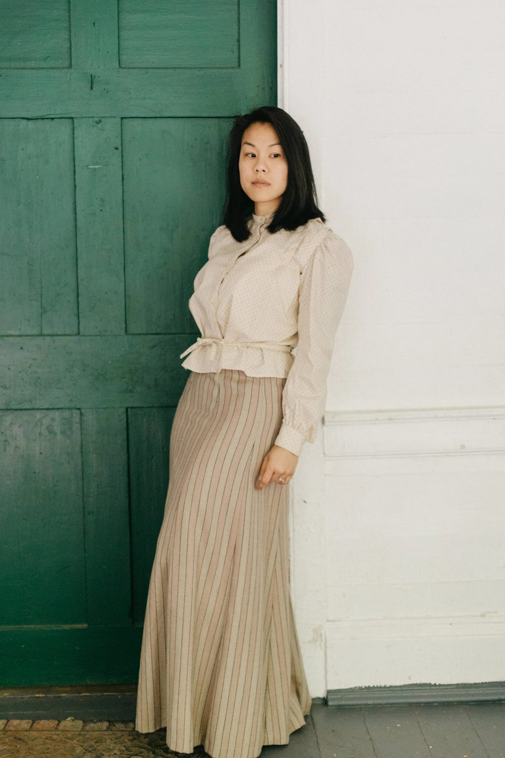 Woman wearing the 216 Schoolmistress Shirtwaist & Skirt sewing pattern from Folkwear on The Fold Line. A blouse and skirt pattern made in cotton broadcloth, poplin, denim, silk, taffeta, noil, linen and blends, medium-weight wool, corduroy, or velveteen f